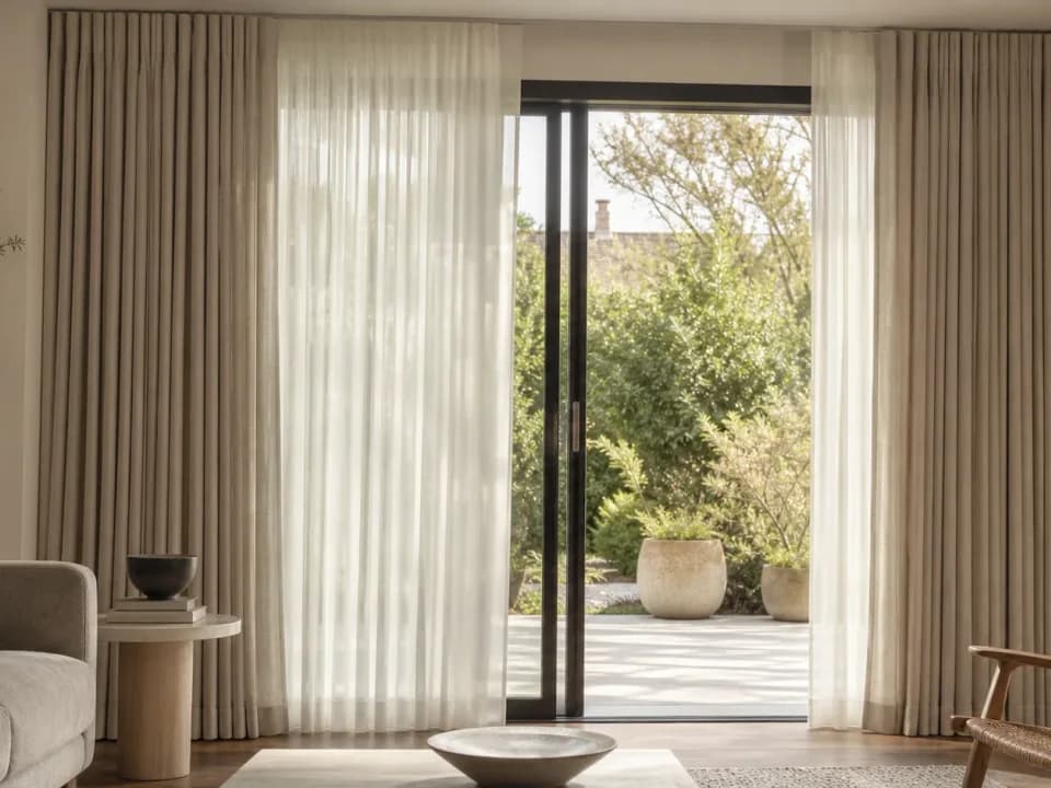 Full-height sheer drapery panels softening daylight in a living room